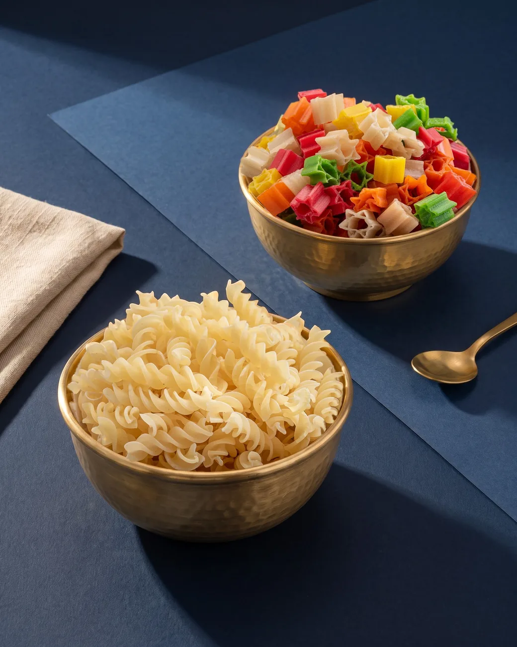Brass bowls of Suvidha Papad Soya Chunks and Star on a navy table in warm sunlight