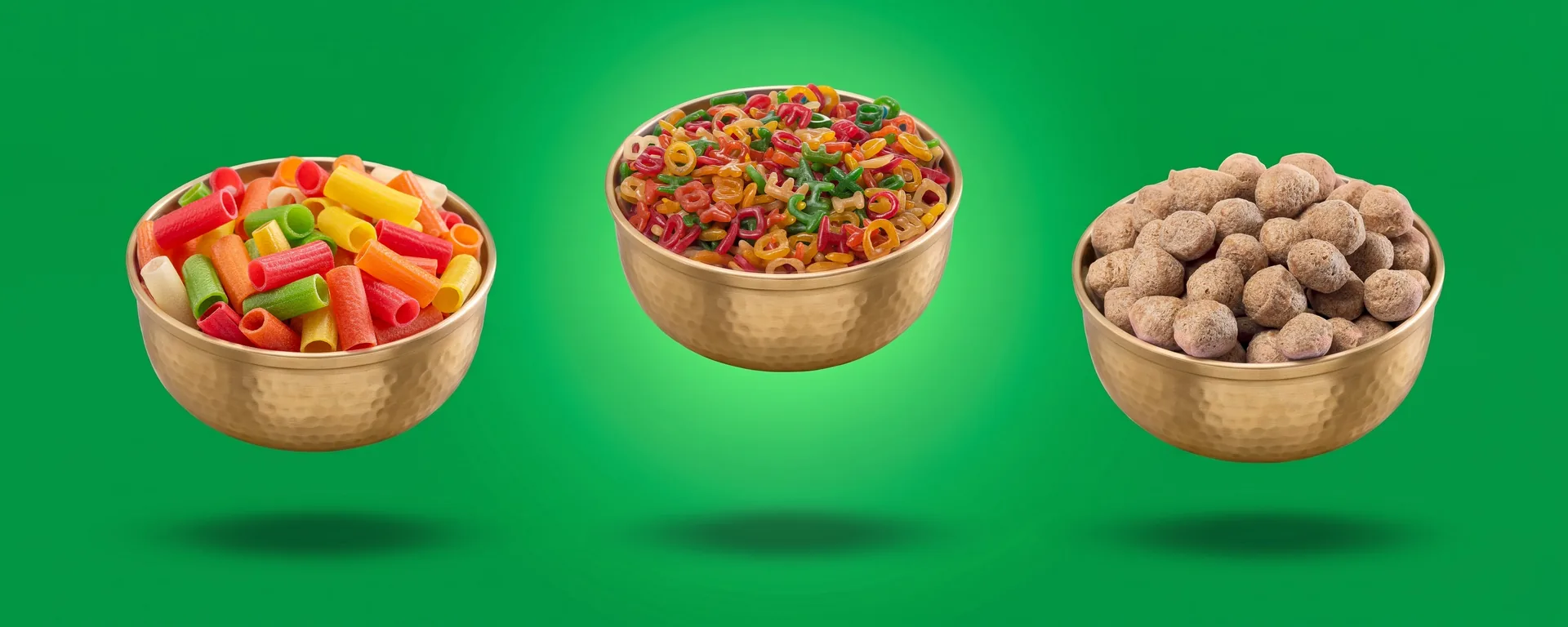 Brass bowls of Suvidha Papad 1-inch Assorted Pipe, ABCD and Soya Chunks floating on a green backdrop